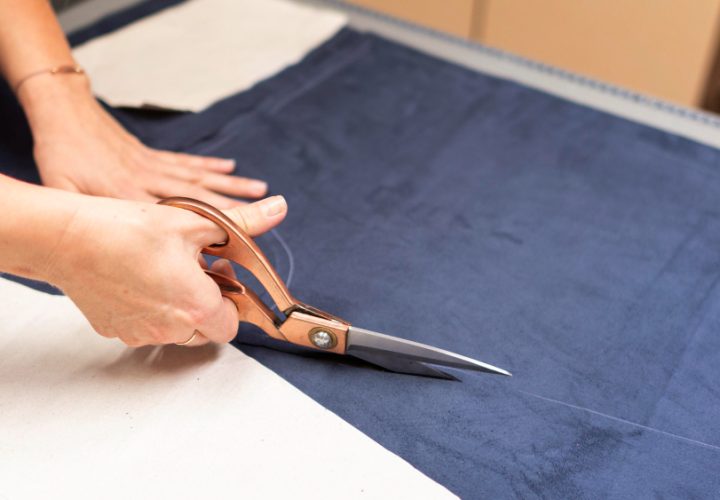 hands-cutting-material-with-scissors-close-up
